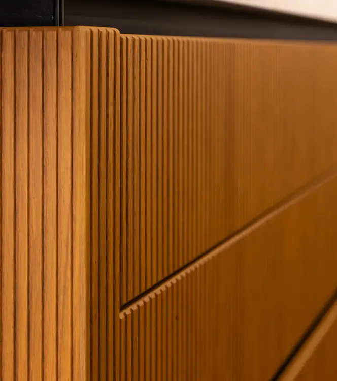 Fluted oak cabinet fronts running floor to ceiling