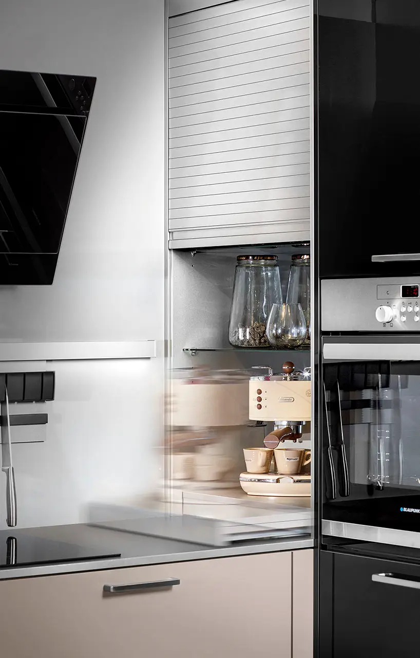 Tall cabinet with pull-out shelves holding a coffee machine and everyday crockery
