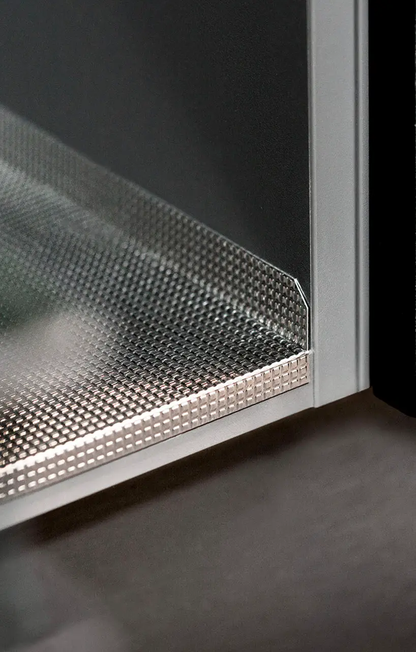 Perforated metal base lining the floor of a sink cabinet to protect against spills
