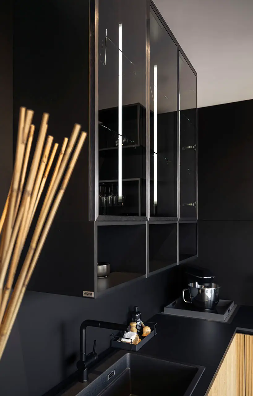 Narrow pull-out storage holding tall dry goods beside a dark cabinet run