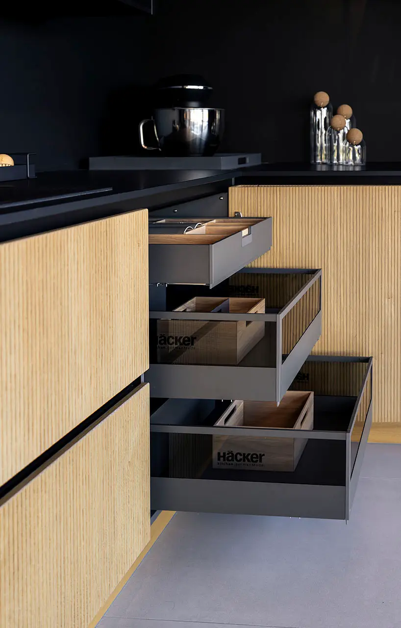 Oak drawer front pulled open to show dark inner drawers with fitted organiser boxes