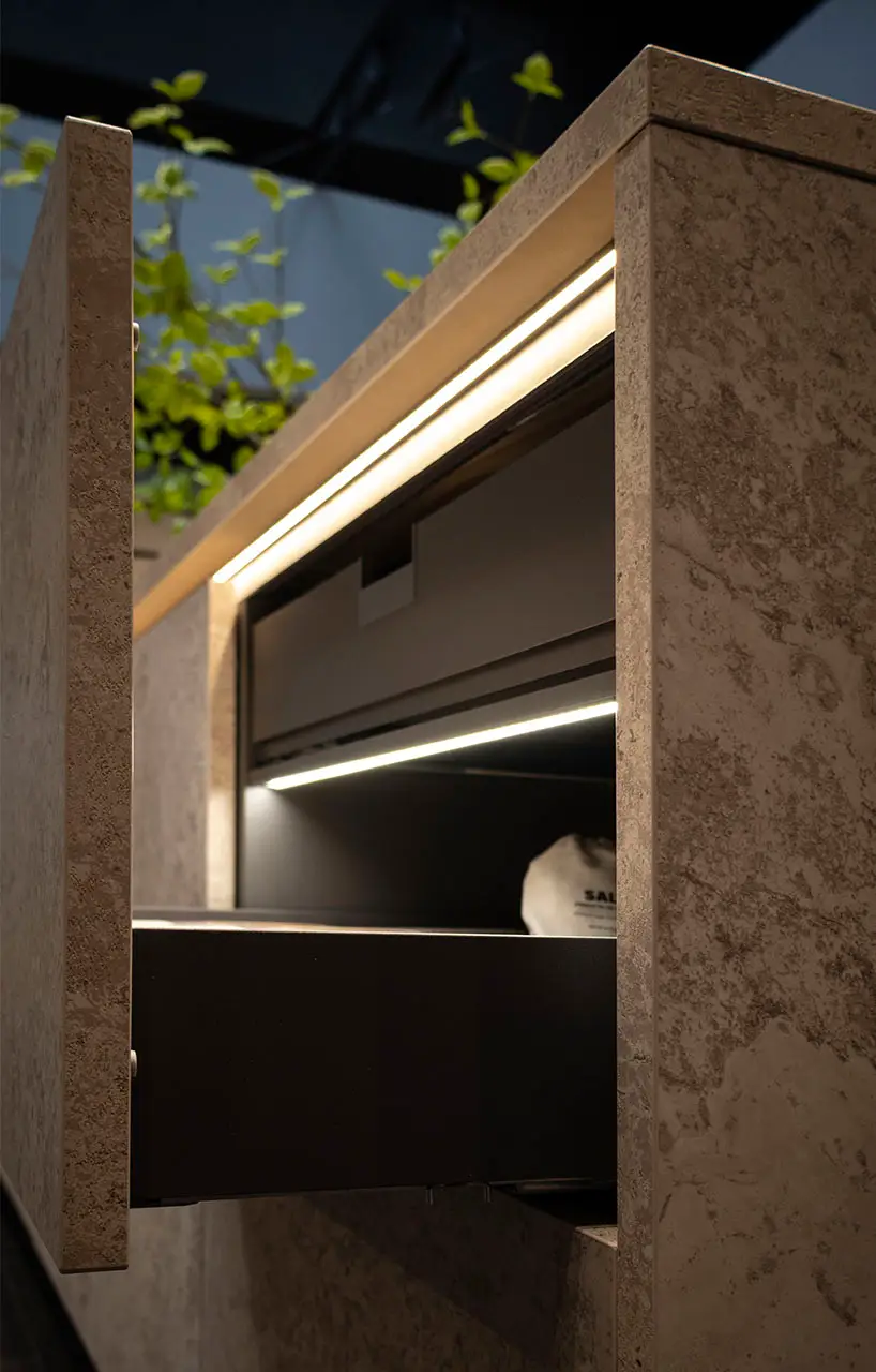 Recessed strip lighting under a wall cabinet above a granite-effect worktop